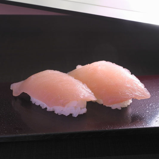 Two pieces of albacore tuna nigiri sushi on a black plate