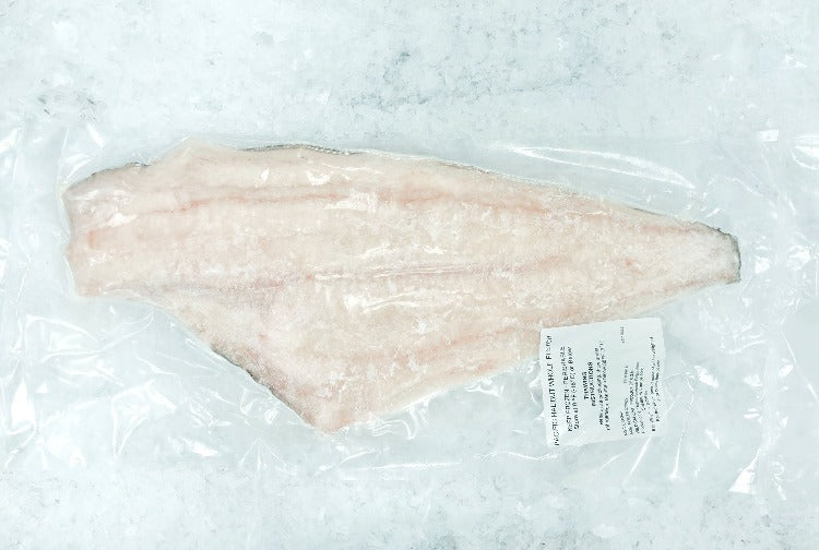 Top view of frozen halibut fillet in clear plastic packaging on ice