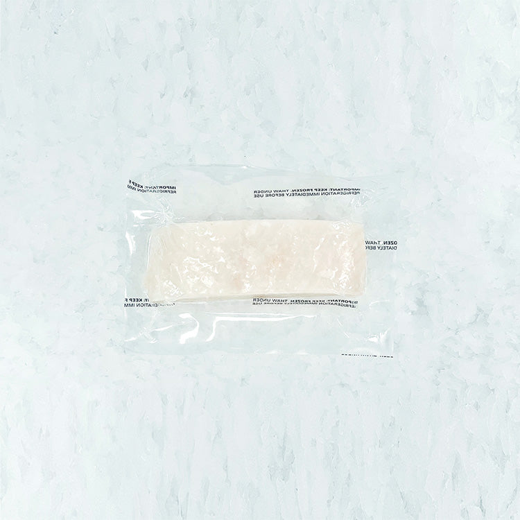 Frozen halibut center cut portion vacuum-sealed in clear plastic packaging, on ice