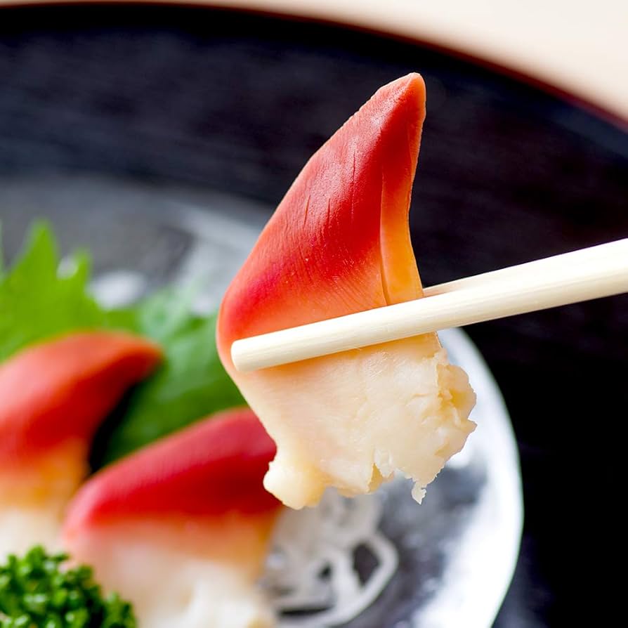 Close-up of fresh Hokkigai (Arctic Surf Clams) sushi held by chopsticks, showcasing the vibrant red and white colors, perfect for sashimi and sushi dishes