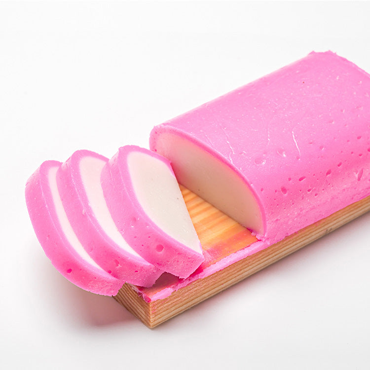 Slices of pink kamaboko fish cake on a plate