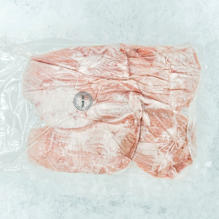 Vacuum-sealed fresh pork jowl slices on crushed ice, marked with a quality assurance label. Ideal for preparing rich and tender meat recipes