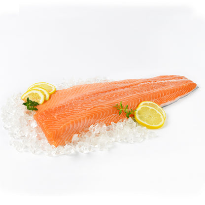 Fresh 'Copper River' king salmon fillet displayed on a bed of crushed ice, garnished with lemon slices and parsley, showcasing the salmon's fresh, vibrant orange color and rich texture