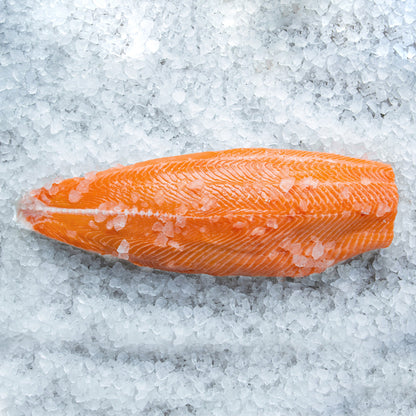 A vibrant, fresh fillet of Copper River King Salmon resting on a bed of crushed ice, showcasing its rich, orange hue and clearly defined texture