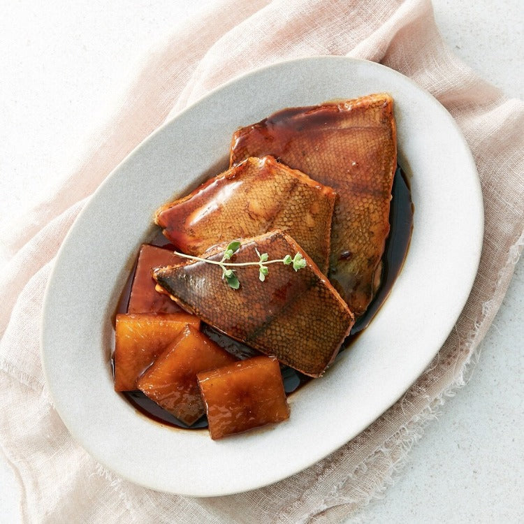 Delicious braised Yellowfin Sole fillets served with soy sauce glaze on a white oval plate