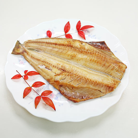 Cooked Atka mackerel fillet served on a decorative plate with red leaves, showcasing a delicious seafood dish