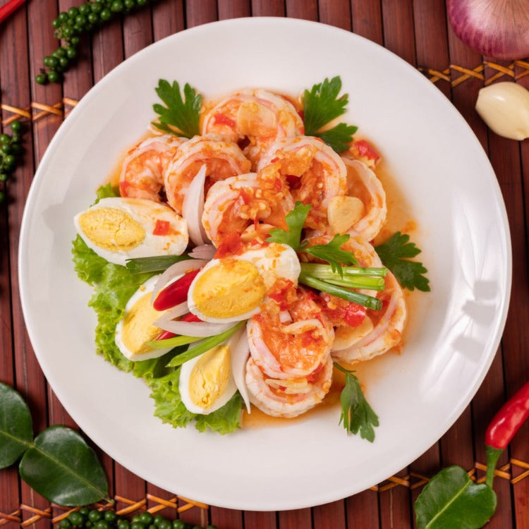 Shrimp Salad with Boiled Eggs, Lettuce, and Scallions on a White Plate