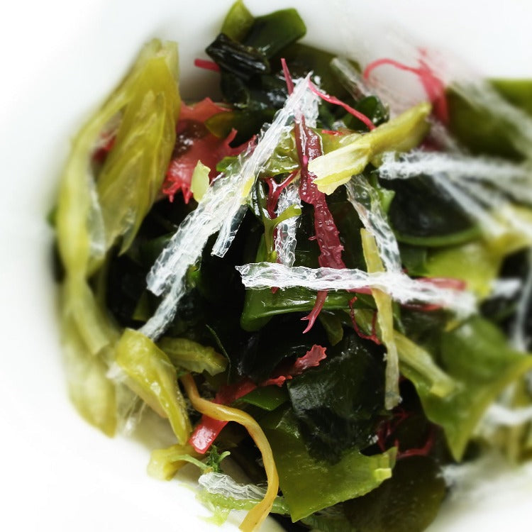 A bowl of seaweed with red and green leaves, a vibrant mix of colors and textures