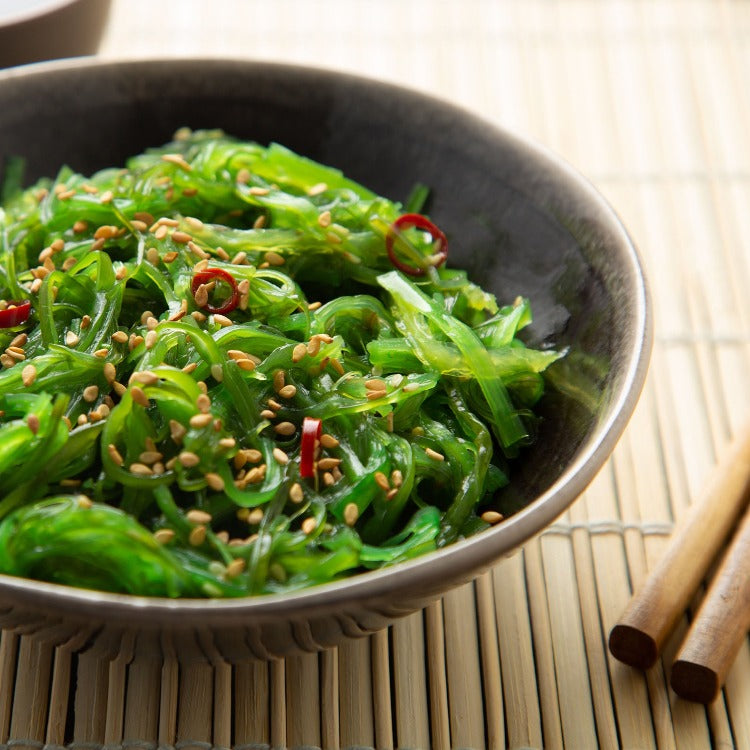 Delicious seasoned seaweed salad in a bowl, topped with sesame seeds and a light dressing